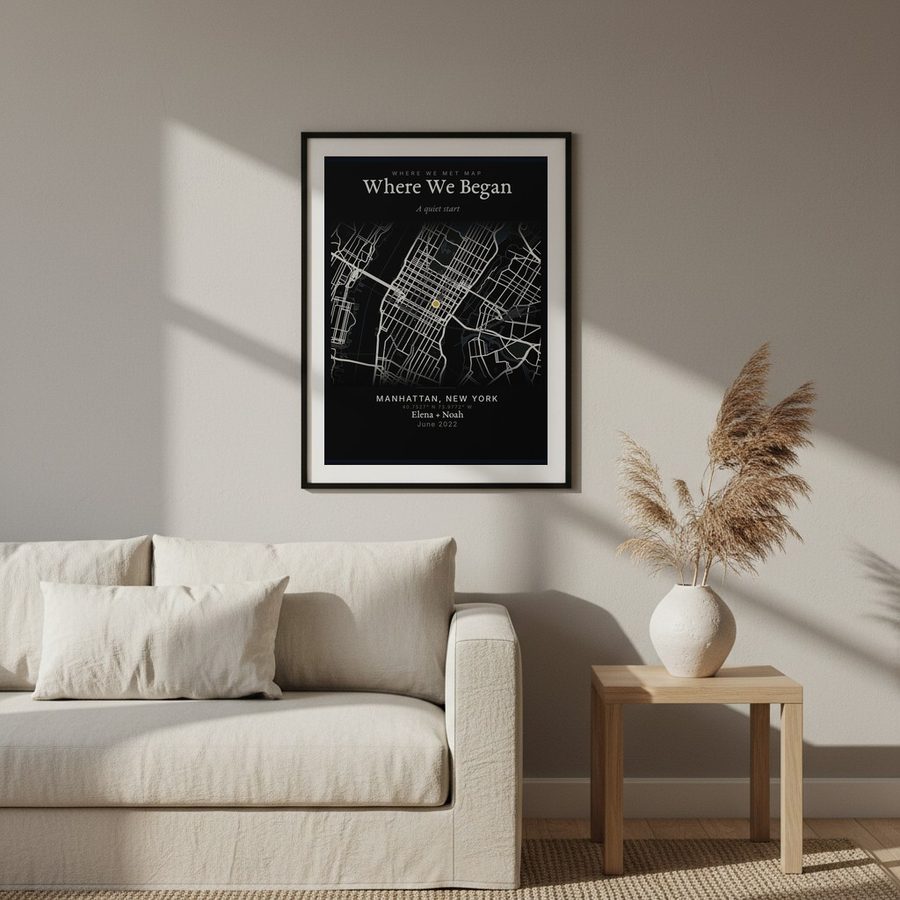 A framed map of Manhattan hanging above a linen sofa in a living room